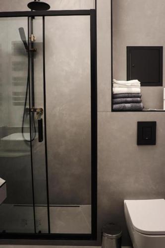 a bathroom with a shower with a glass door at Hotel Apart in Warsaw