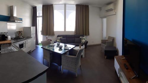 uma cozinha e sala de estar com um sofá e uma mesa em Cosy Home Papeete em Papeete