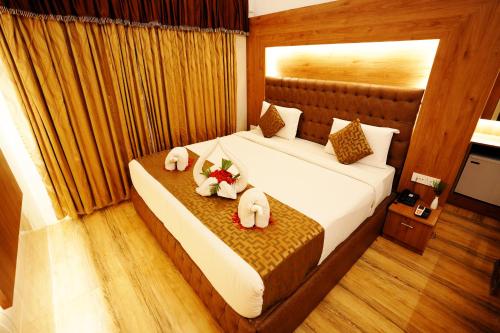 a bedroom with a bed with two stuffed animals on it at Jal Mahal Resort and Spa in Mysore