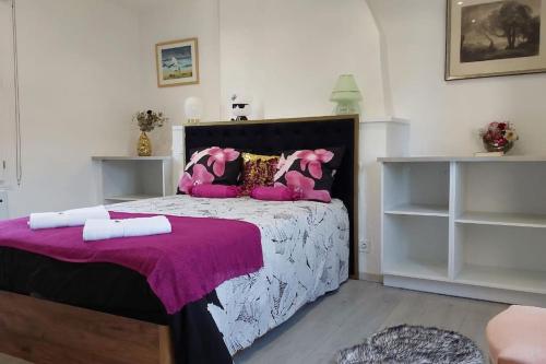 une chambre avec un grand lit avec des oreillers roses dans l'établissement Maison avec jardin Honfleur, à Honfleur