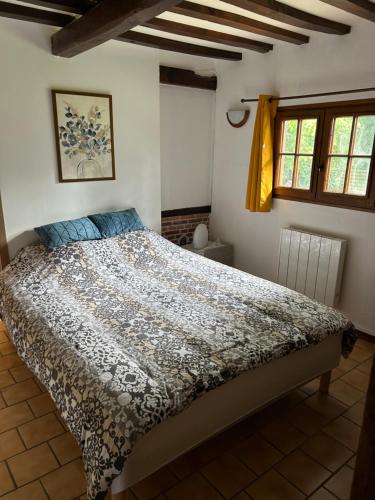 a bedroom with a large bed in a room with windows at Maison normande gîte la Cavellerie in Bonneville-la-Louvet