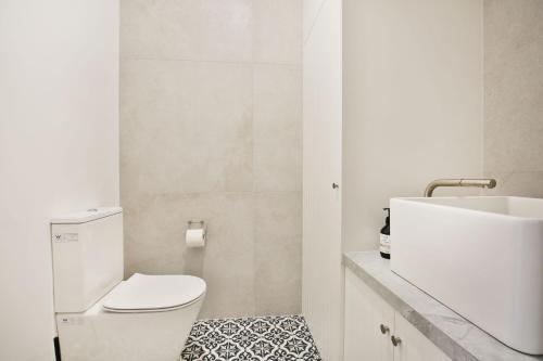 a white bathroom with a toilet and a sink at Camellia - Pet Friendly - 3 Min Walk to Centre of Berry in Berry