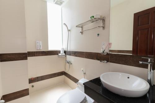 ein Badezimmer mit einem weißen WC und einem Waschbecken in der Unterkunft Sunny Guesthouse2 in Ho-Chi-Minh-Stadt