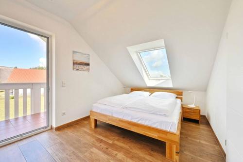 トレントにあるVilla Seeadlerのベッドと大きな窓のある白い寝室