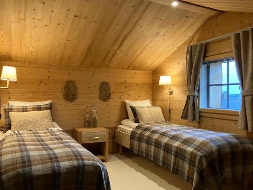 1 dormitorio con 2 camas en una cabaña de madera en VILLA TUNDRA en Ruka