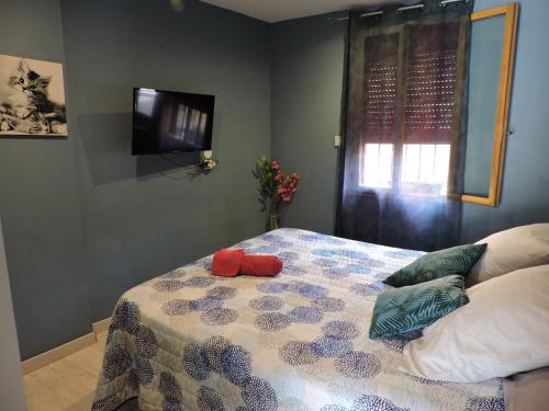a bedroom with a bed with pillows and a television at Arum in Codalet