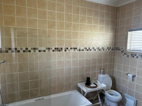 ein Badezimmer mit Toilette und Badewanne in der Unterkunft Cozy Cottage Accommodation in Johannesburg in Roodepoort