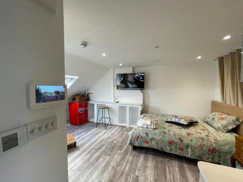 pokój hotelowy z łóżkiem i telewizorem w obiekcie Luxury Rooms with En-suite bathrooms - West London w mieście Harrow on the Hill