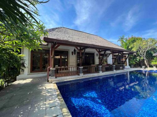 a swimming pool with a gazebo next to a house at Bali Berg Villa, Sanur in Sanur