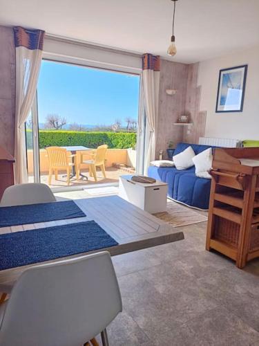 un salon avec un canapé bleu et une table dans l'établissement Le Studi O, à La Chaume