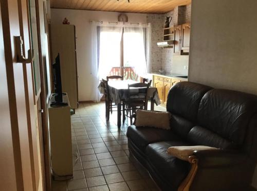 un salon avec un canapé et une table dans une cuisine dans l'établissement Gîte Chevenoz, à Chevenoz