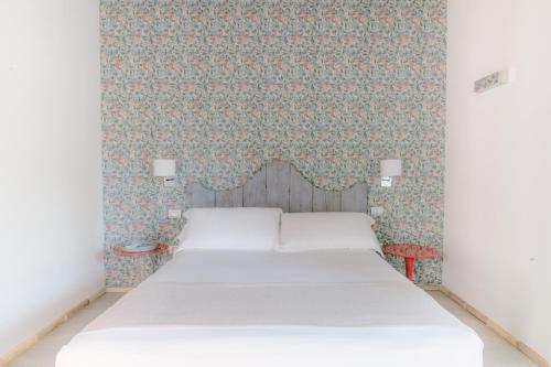 una camera con letto e parete con carta da parati di Casa Saba ospitalità con vista a Rustico