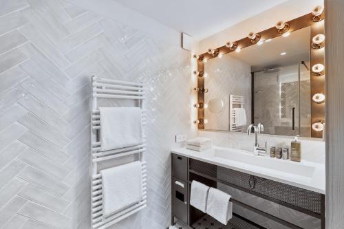 a bathroom with a sink and a mirror at H4 Hotel Wyndham Paris Pleyel Resort in Saint-Denis