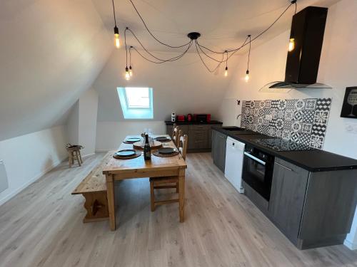 Il comprend une cuisine avec une table en bois et du parquet. dans l'établissement Le Nid de Chantal, à Brienne-le-Château