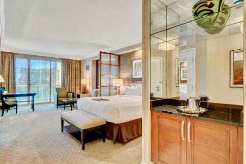 a hotel room with a bed and a desk at Strip View Balcony Suites - No Resort Fee ! in Las Vegas