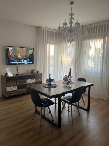 uma sala de jantar com uma mesa e cadeiras e uma televisão em Ca’ Uccelli-Stupendo Appartamento 5 min da Venezia em Marghera