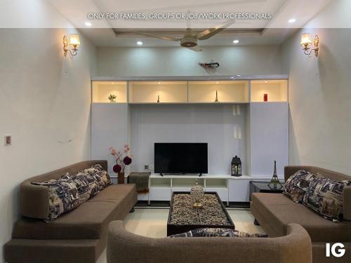 a living room with two couches and a flat screen tv at Furnished Luxury Holiday and Vacation Home in Lahore