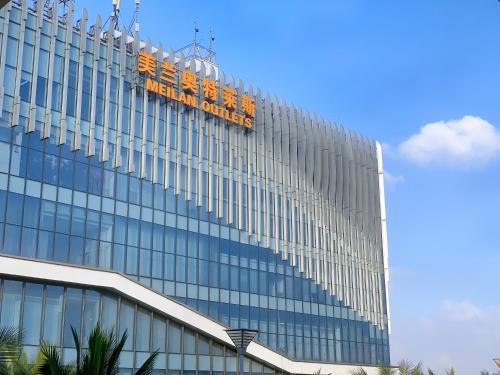 a building with a sign on the side of it at Haikou Meilan International Airport Hotel in Haikou