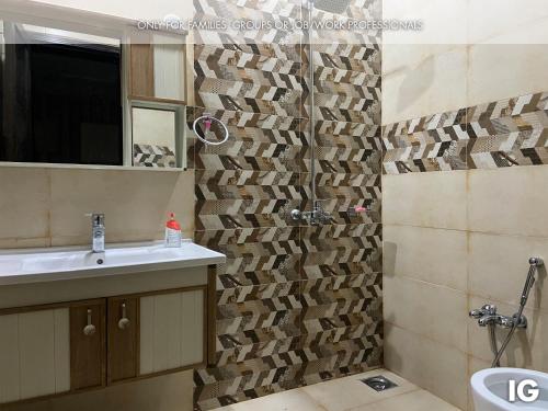 a bathroom with a sink and a toilet and a mirror at Spacious 3 Bedroom Furnished Family Home near Valencia Town, Lake City & Ring Road in Lahore