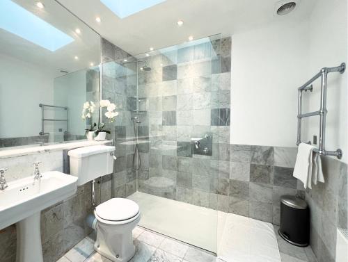 uma casa de banho com um chuveiro, um WC e um lavatório. em Museum ST Central Soho Apartment em Londres