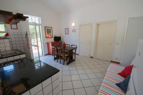 a kitchen and living room with a table and chairs at Azienda Agricola Sapereta in Porto Azzurro