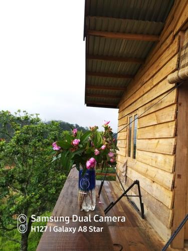 a vase of flowers sitting on a porch of a house at Tuyên Chiến Home - Nhà Gỗ in Ấp An Kroët