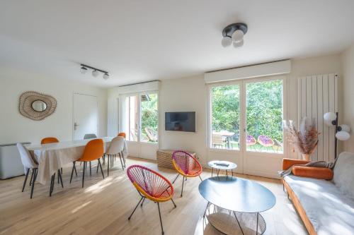 uma sala de estar com um sofá, cadeiras e uma mesa em Nice house with a yard and common pool - Deauville - Welkeys em Deauville