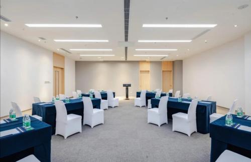 a conference room with blue tables and white chairs at Haikou Meilan International Airport Hotel in Haikou