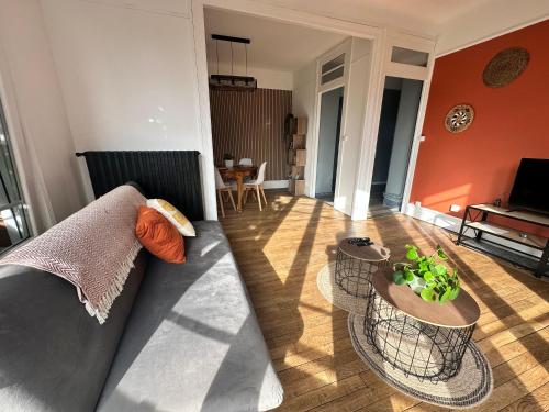 sala de estar con sofá y 2 mesas en Appartement lumineux et spacieux, en Charleville-Mézières