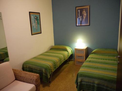 una camera d'albergo con due letti e una sedia di Apartment Obici a Spilamberto