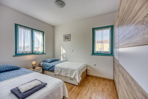 sypialnia z dwoma łóżkami i dwoma oknami w obiekcie Apartment Anita w mieście Gedići