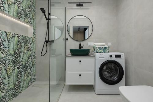 a bathroom with a washing machine and a mirror at Shellter Apartments 117 K - by Jantar Apartamenty in Rogowo