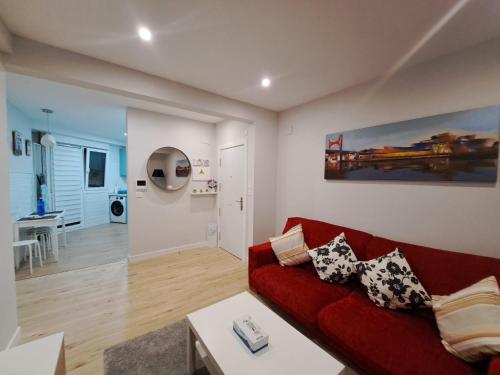 sala de estar con sofá rojo y mesa en Apartamento Encanto, en Bermeo