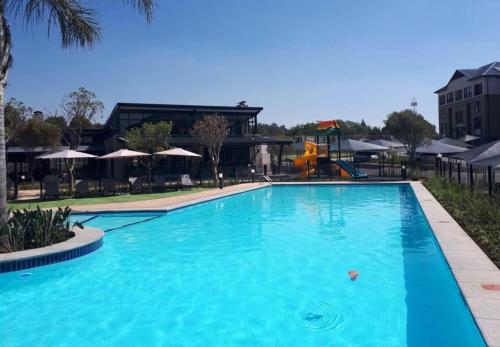 une grande piscine bleue dans un complexe dans l'établissement Kikuyu Lifestyle Escapade de Luxe, à Midrand