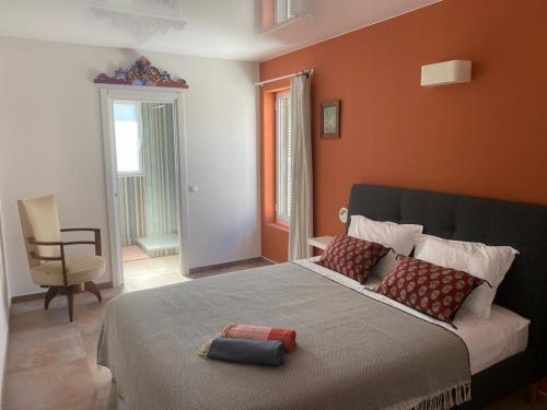 a bedroom with a large bed with an orange wall at Casa S’Arraval in Mahón