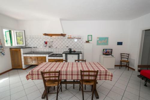 a kitchen with a table and chairs in a room at Azienda Agricola Sapereta in Porto Azzurro