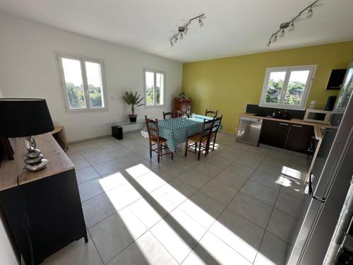 une cuisine et un salon avec une table et des chaises dans l'établissement La maison lumineuse de Bernis, à Bernis