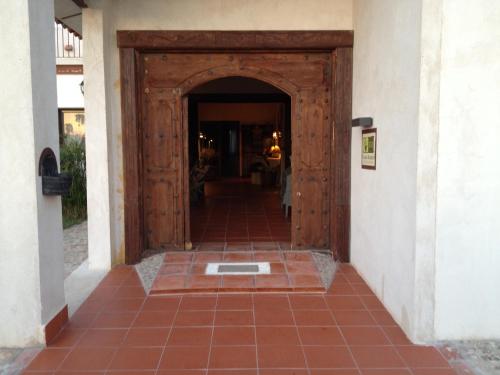 a wooden door leading into a hallway with a tile floor at La Simona in Los Cerralbos