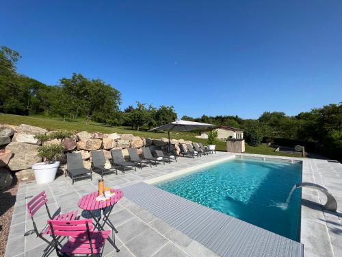 - une piscine avec des chaises roses, une table et une table dans l'établissement La Villa en Loire, avec Jacuzzi 6 places, Piscine chauffée, boulodrome, salle de jeu, 6 Chambres, vue Loire, 350M2, à La Charité-sur-Loire