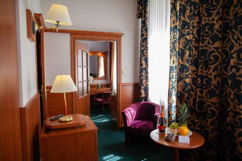 a hotel room with a chair and a table at Pietrak Hotel in Gniezno