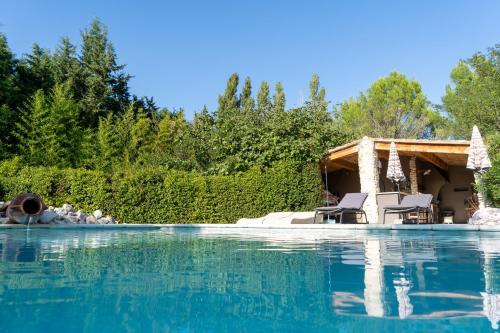 una piscina con sillas y una casa en Mirabelle en Provence, en Eygalières