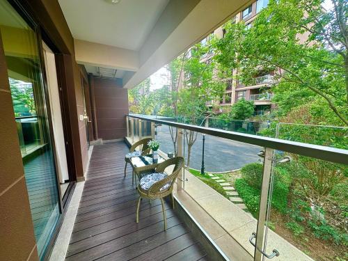 a balcony with two chairs and a table on it at Colorful Yunnan Absolutely Beautiful Dian B&B in Kunming