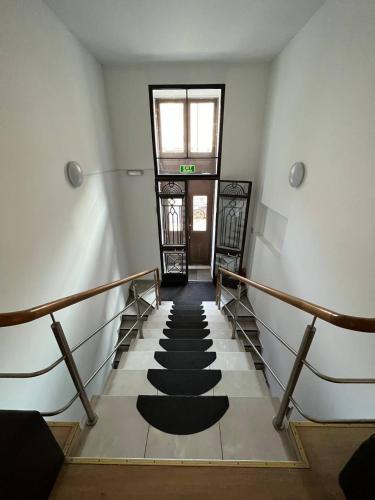 a hallway with a stairway with black mats on it at Centro Hostel in Vilnius