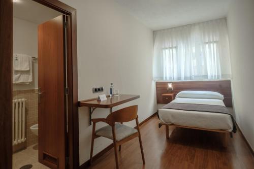タピア・デ・カサリエゴにあるHotel Restaurante San Antonのベッドルーム1室(ベッド1台、テーブル、椅子付)