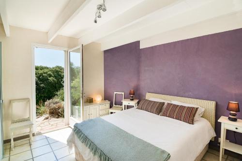 Saint-Martin-de-LondresにあるVilla Mas de Bouisの紫の壁のベッドルーム1室(ベッド1台付)