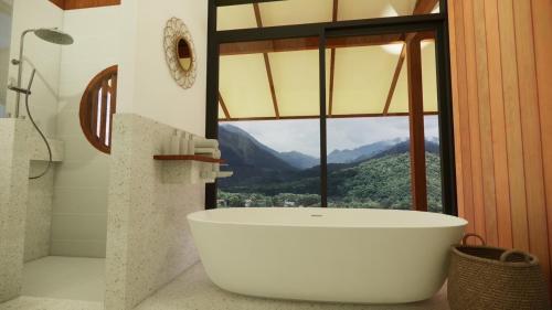 Baño con bañera grande frente a una ventana en Utopua Resort ยูโทปัวว์ รีสอร์ท, en Pua