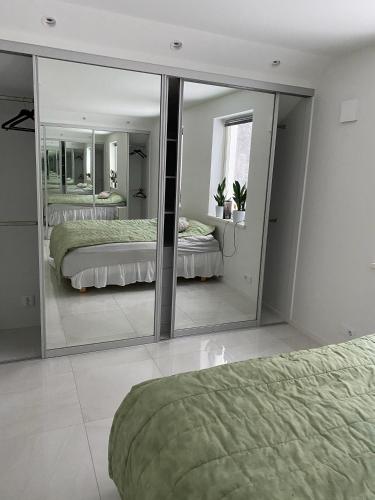 a bedroom with two beds and a large mirror at Natursköna in Borås