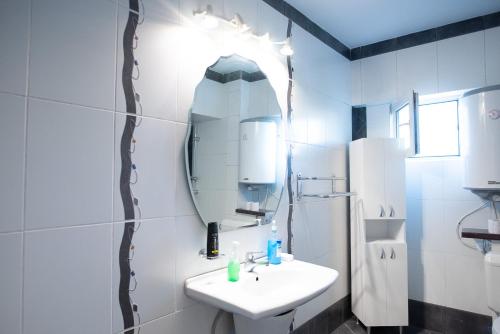 a white bathroom with a sink and a mirror at 5 Bedrooms Luxury Apartment Villa in Bucharest