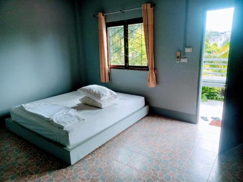 uma cama num quarto com uma janela em MSD House em Ko Por