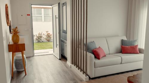 a living room with a white couch and a sliding glass door at Shellter Apartments by the sea in Vieira de Leiria